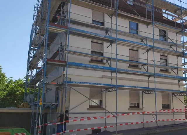 Gerüst an der Fassade eines Mehrfamilienhauses während des Fenstertauschs